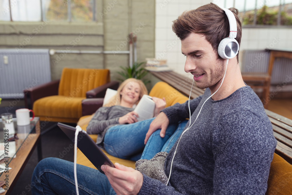 paar entspannt zu hause mit lesen und musik hören paar entspannt zu hause mit lesen und musik hören