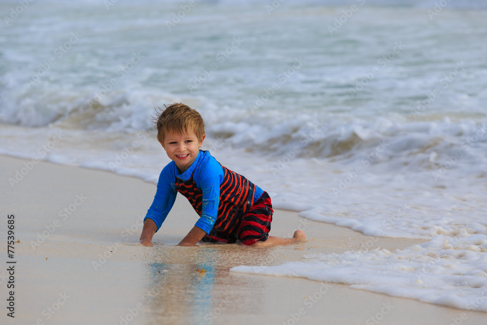 little boy playing with waves on sand beach little boy playing with waves on sand beach