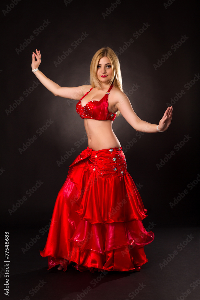 Beautiful girl in a suit oriental dance on black background Beautiful girl in a suit oriental dance on black background