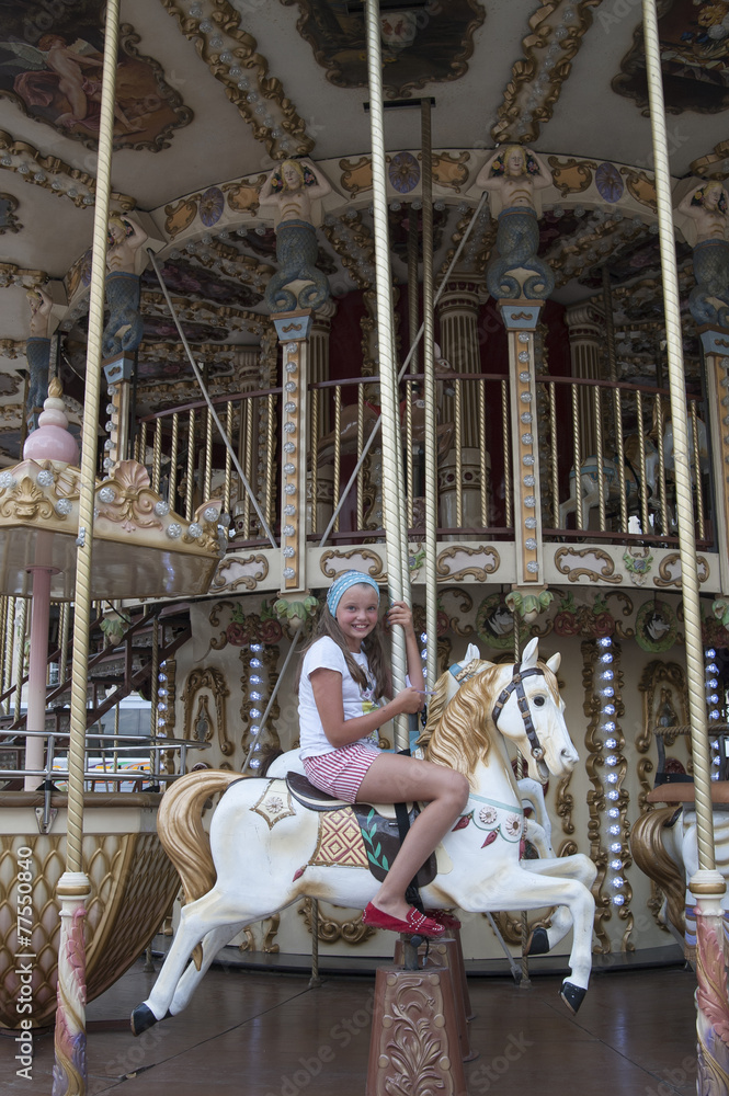 Ten-year girl riding a classic French carousel.