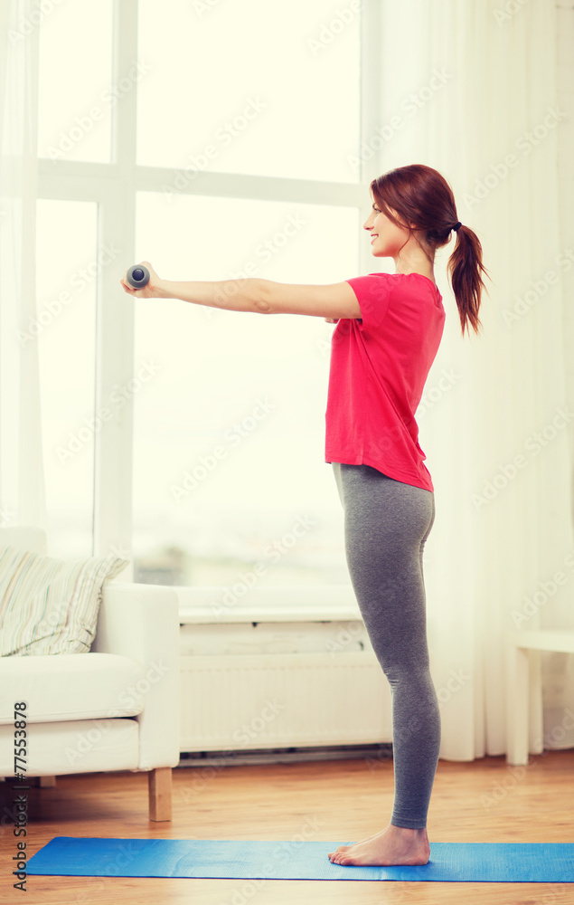 smiling teenage girl exercising with dumbbells smiling teenage girl exercising with dumbbells