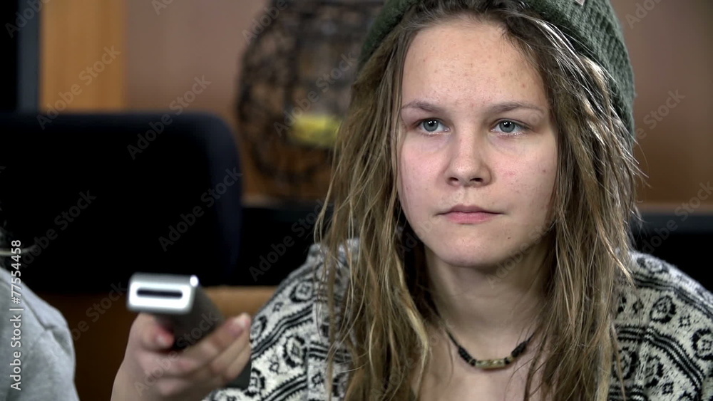 Girl with dreadlocks watches the television Girl with dreadlocks watches the television