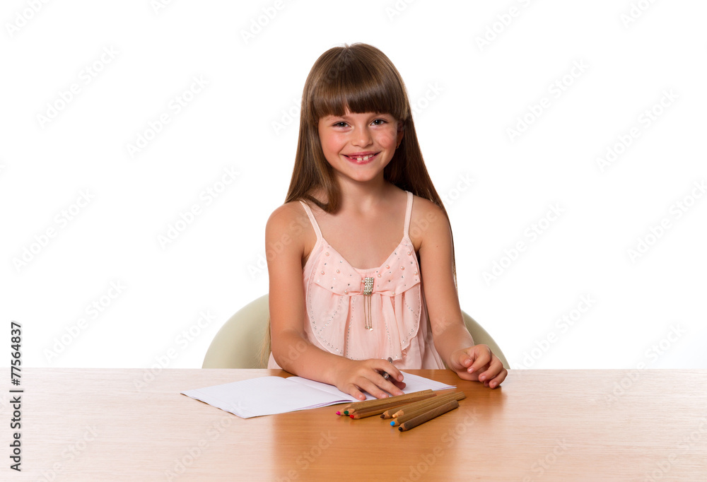 Beautiful little girl draws while sitting at a table Beautiful little girl draws while sitting at a table
