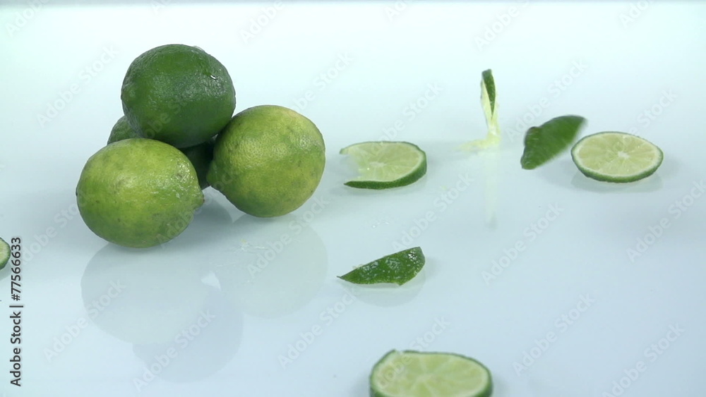 Pile of limes with falling slices of the same citrus Pile of limes with falling slices of the same citrus