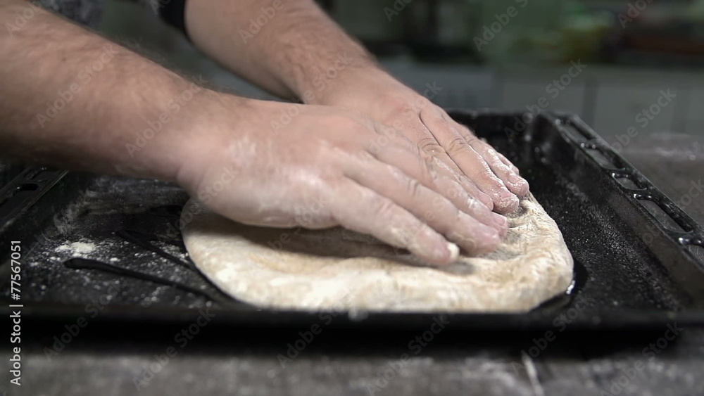 Stretching the dough over the bakeware in slow motion Stretching the dough over the bakeware in slow motion