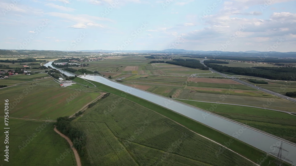 Panorama slide shot from helicopter representing river-bed that slowly passes through a beautiful green valley with highway on the right side of the river Panorama slide shot from helicopter representing river-bed that slowly passes through a beautiful green valley with highway on the right side of the river