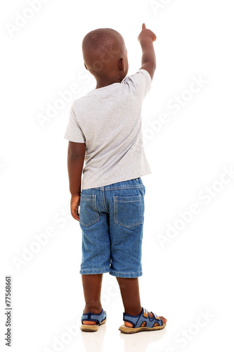 Фотография back view of little african boy pointing