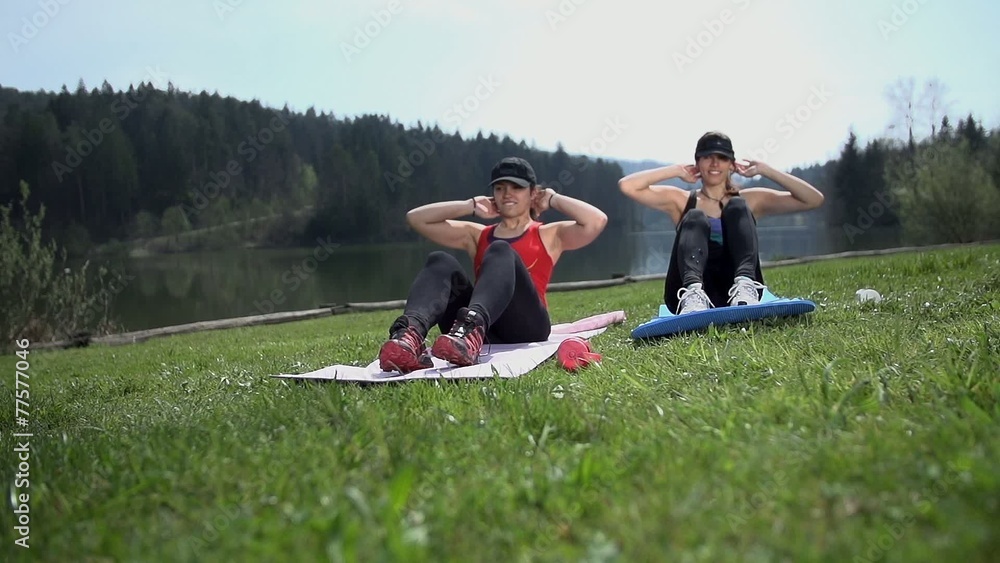 Wide Angle Two Women Doing Sit-ups At Lake on Grass
Wide Angle Two Women Doing Sit-ups At Lake on Grass