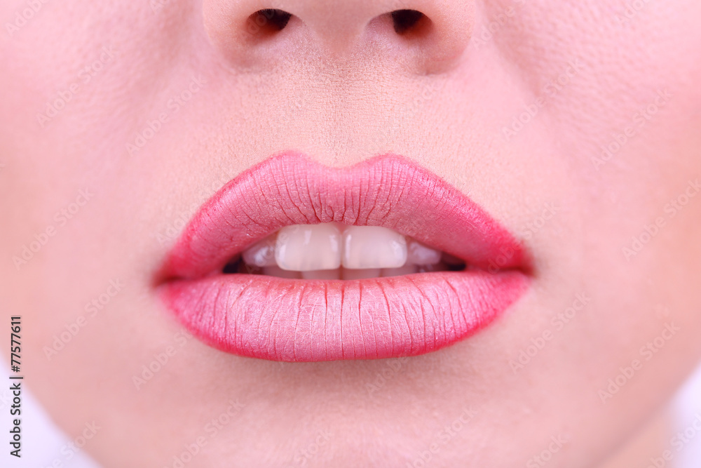 Fototapeta premium Applying lipstick on lips, on white background