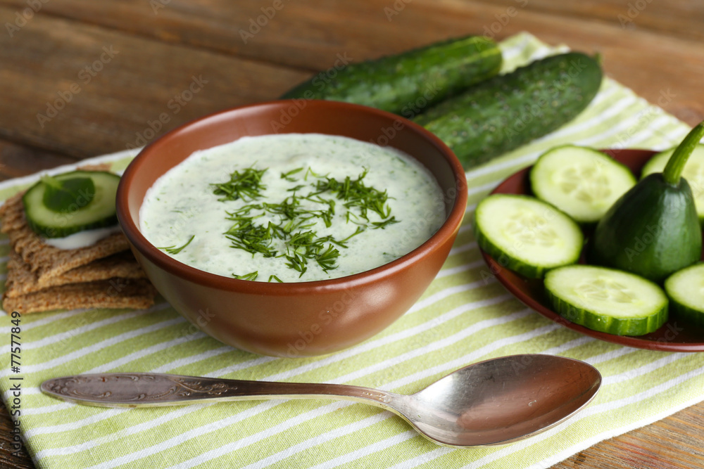Cucumber soup in bowl on rustic wooden table background Cucumber soup in bowl on rustic wooden table background