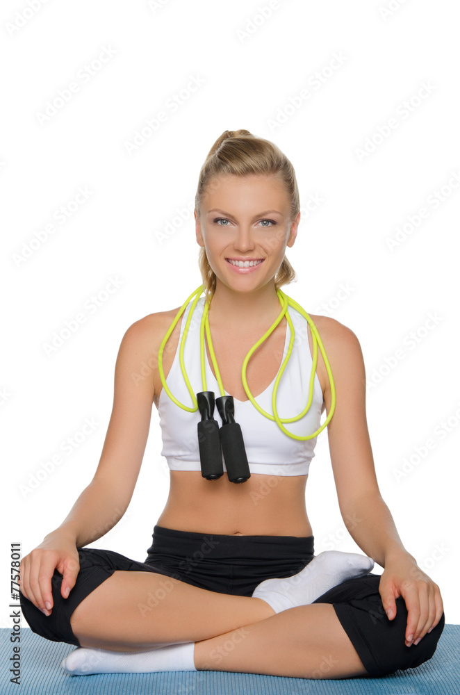 woman with rope on his shoulders sits, blue mat