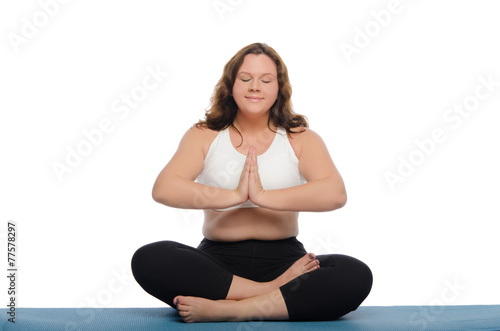 woman with overweight is meditating on mat
