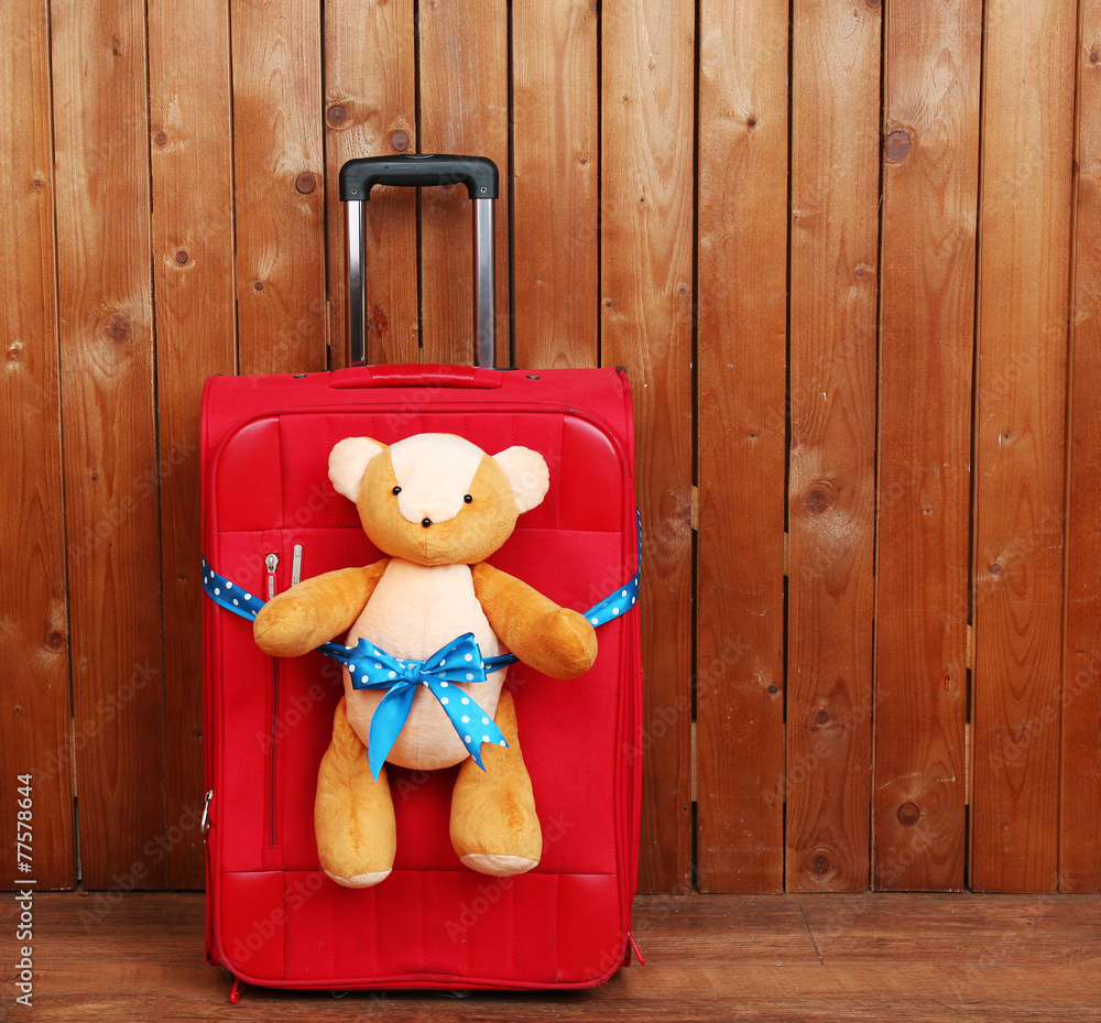 Suitcase with teddy bear on wooden planks background foto de Stock Adobe Stock