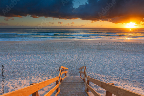 Australian beach entry with stairs in foreground at sunrise