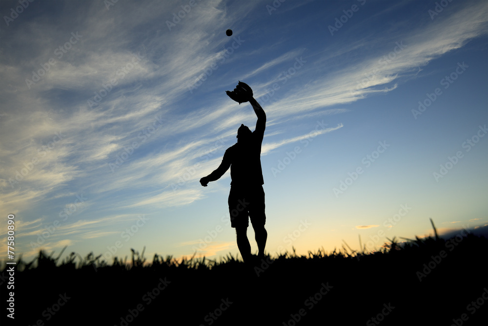 A man silhouetted by the sunset is just beginning catch ball A man silhouetted by the sunset is just beginning catch ball