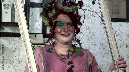 Lady with plant hat is holding a rotating wooden frame  photo