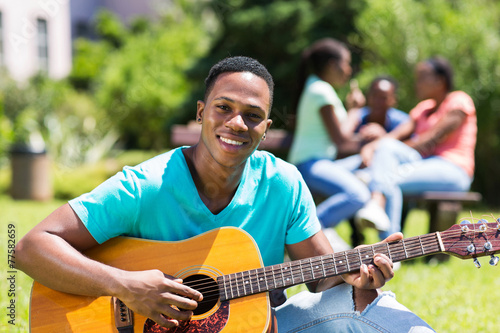 male african college boy playing guitar