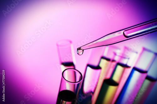 Pipette adding fluid to the one of test-tubes