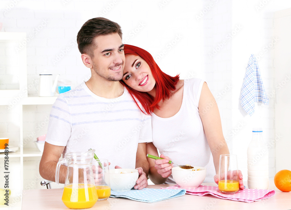 Happy couple has breakfast in kitchen Happy couple has breakfast in kitchen