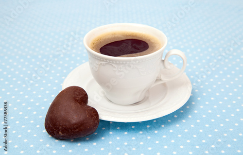 Cup of espresso and chocolate cookies in the shape of a heart