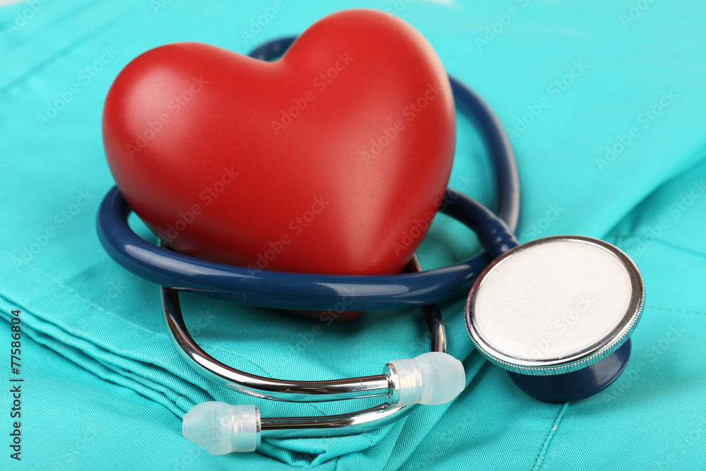 Stethoscope with heart on suit background, close-up - obrazy, fototapety, plakaty 