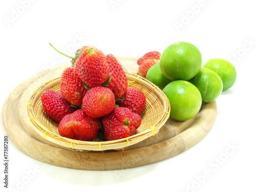 strawberry fruits on wooden chopping board over white background