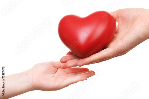 Heart in child and mother hands isolated on white