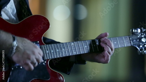 Man playing the red guitar at night-time photo