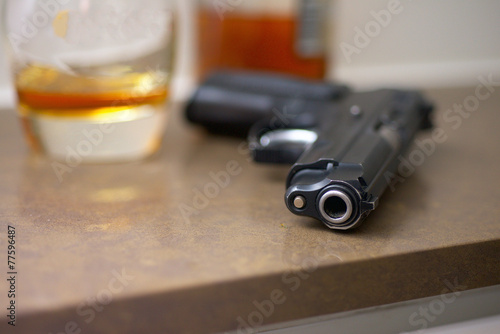Gun, glass, bottle on the table