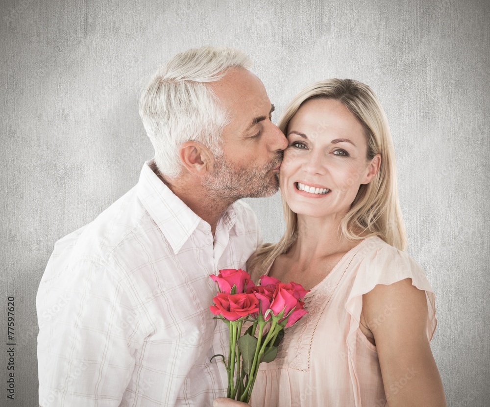 Affectionate man kissing his wife on the cheek with roses Affectionate man kissing his wife on the cheek with roses
