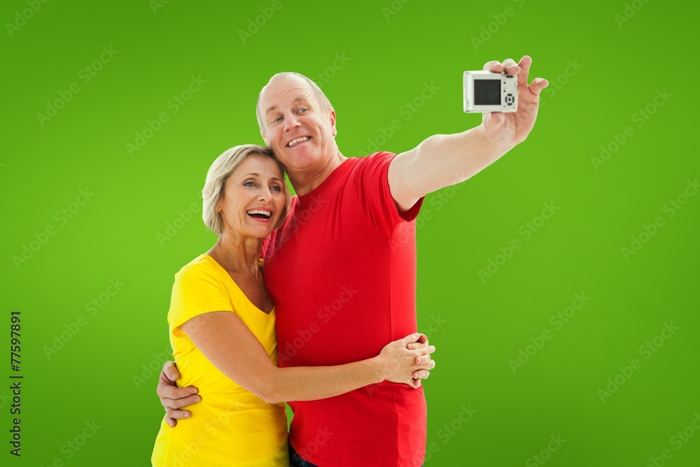 Composite image of happy mature couple taking a selfie together Composite image of happy mature couple taking a selfie together