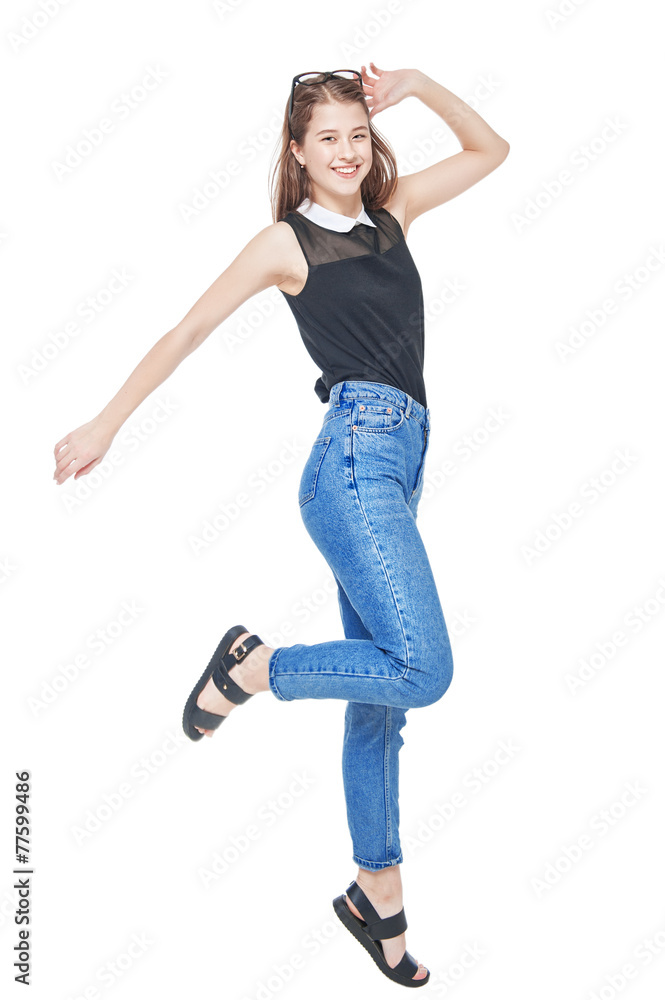 Happy young fashion girl in jeans jumping isolated Happy young fashion girl in jeans jumping isolated