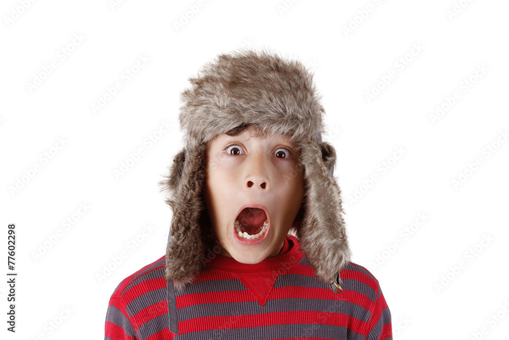Boy in furry hat puloling funny faces on white background Boy in furry hat puloling funny faces on white background