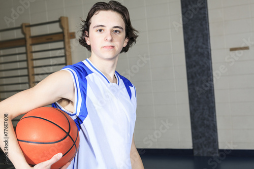 A teenager basketball player play his favorite sport