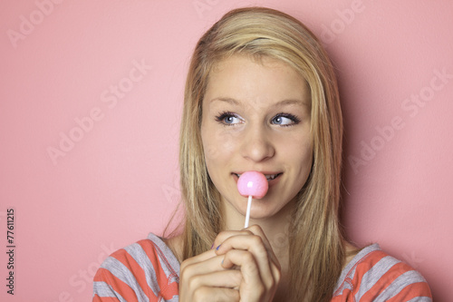 girl with lollipop sitting on her bedroom