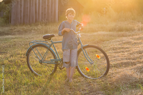 Smiling teenager boy standing with bicycle