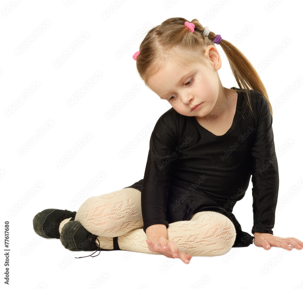 Little Girl dancer sits on White Background
