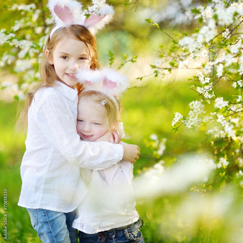 Two little sisters wearing bunny ears on Easter Two little sisters wearing bunny ears on Easter