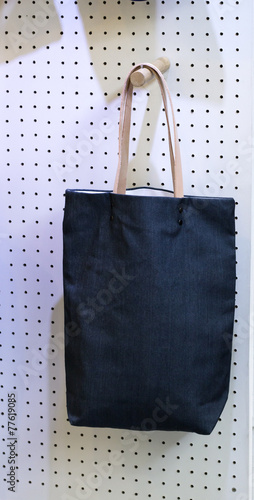 Indigo Jeans kitbag hang on board at display handmade shop. photo