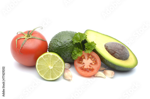 Fresh avocado surrounded by  tomato and lime