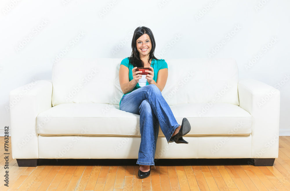 A Young woman using a cellphone on the sofa A Young woman using a cellphone on the sofa