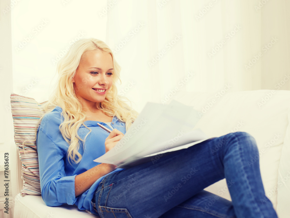 Obraz premium smiling young woman with papers at home