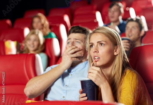 friends watching horror movie in theater