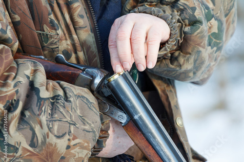 hunter loading his old double-barreled side by side shotgun