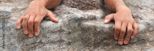 Rock climbers hands holding onto edge