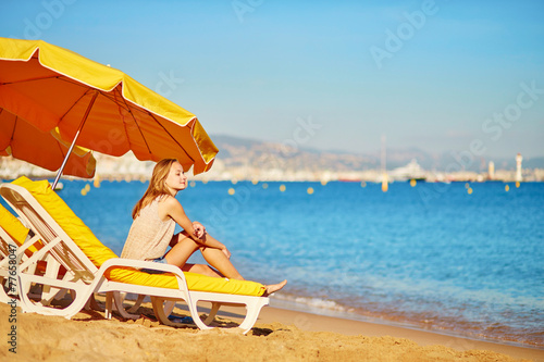 Girl relaxing on a beach chair near the sea © Ekaterina Pokrovsky