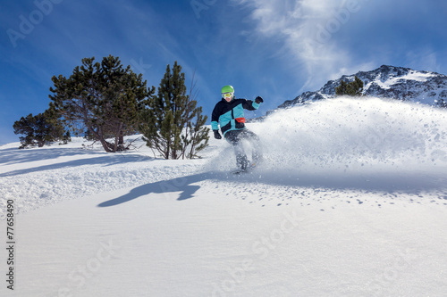 Snowboarder moving down photo