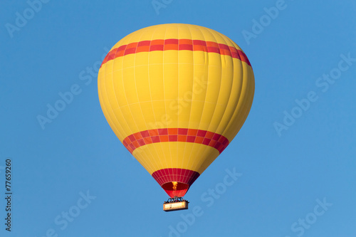 A hot air balloon flying on a clear sky day. © tanarch