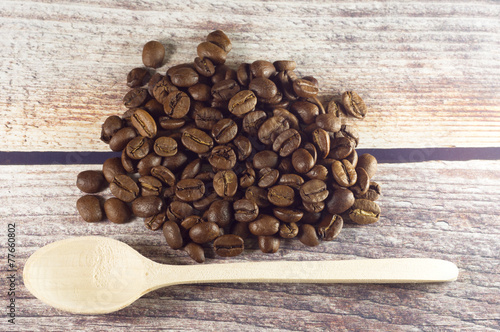 Obraz na płótnie Black coffee and wooden spoon near coffee grains on vintage wooden background w salonie