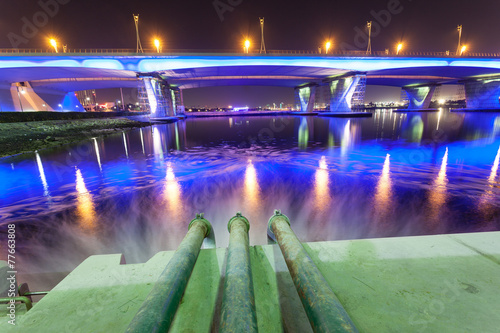 Canvas Print Sewage pipes discharging water into Dubai Creek